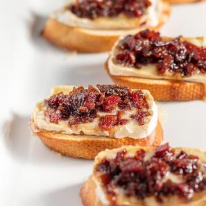 crustine topped with cheese and bacon jam