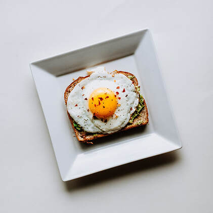 fried egg on a slice of toast with green spread